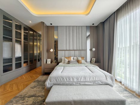 Luxurious modern bedroom design featuring large windows and sophisticated decor.