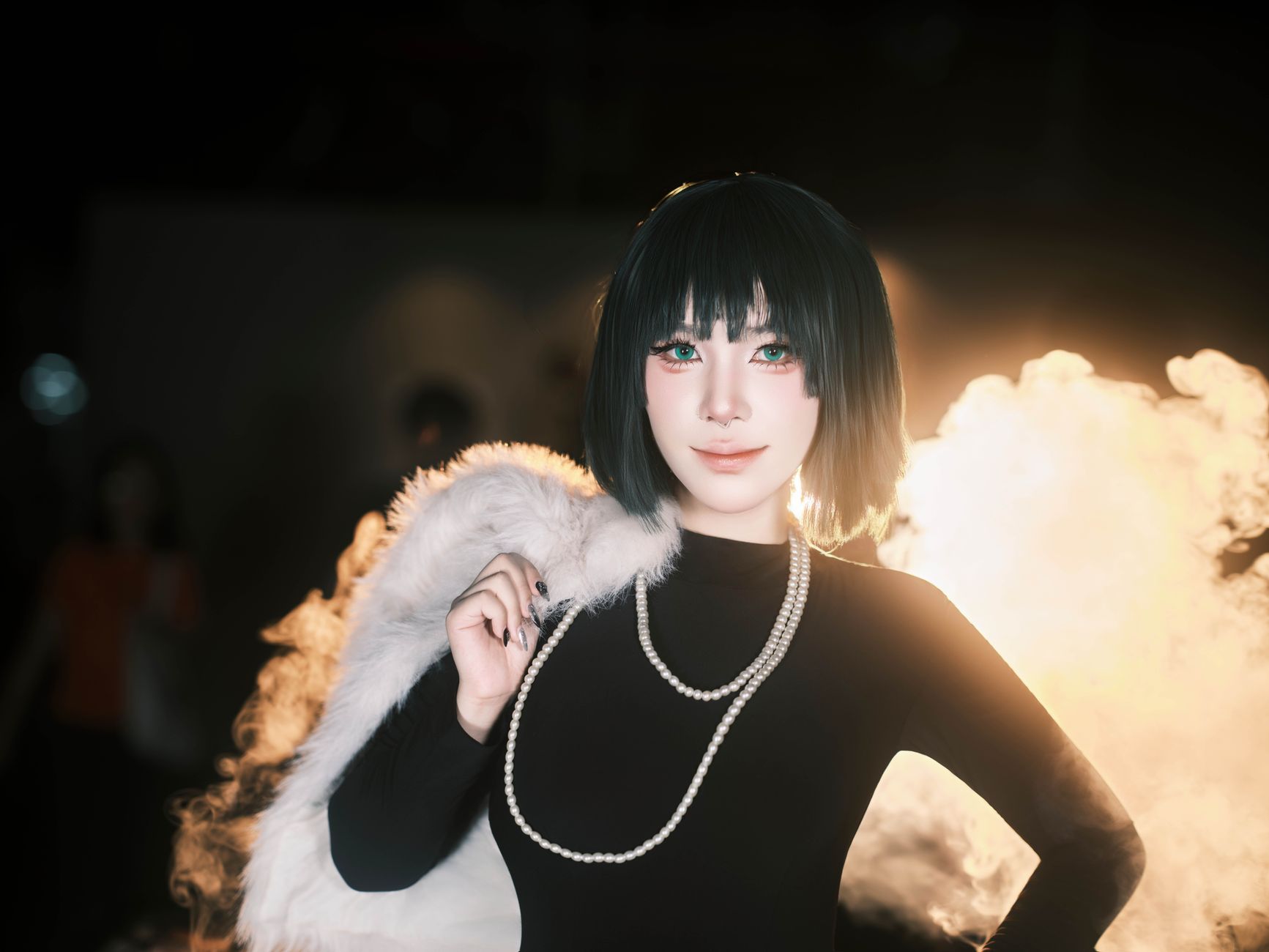 Chic woman in a black dress, fur stole, and pearls, radiates elegance against a smoky backdrop.