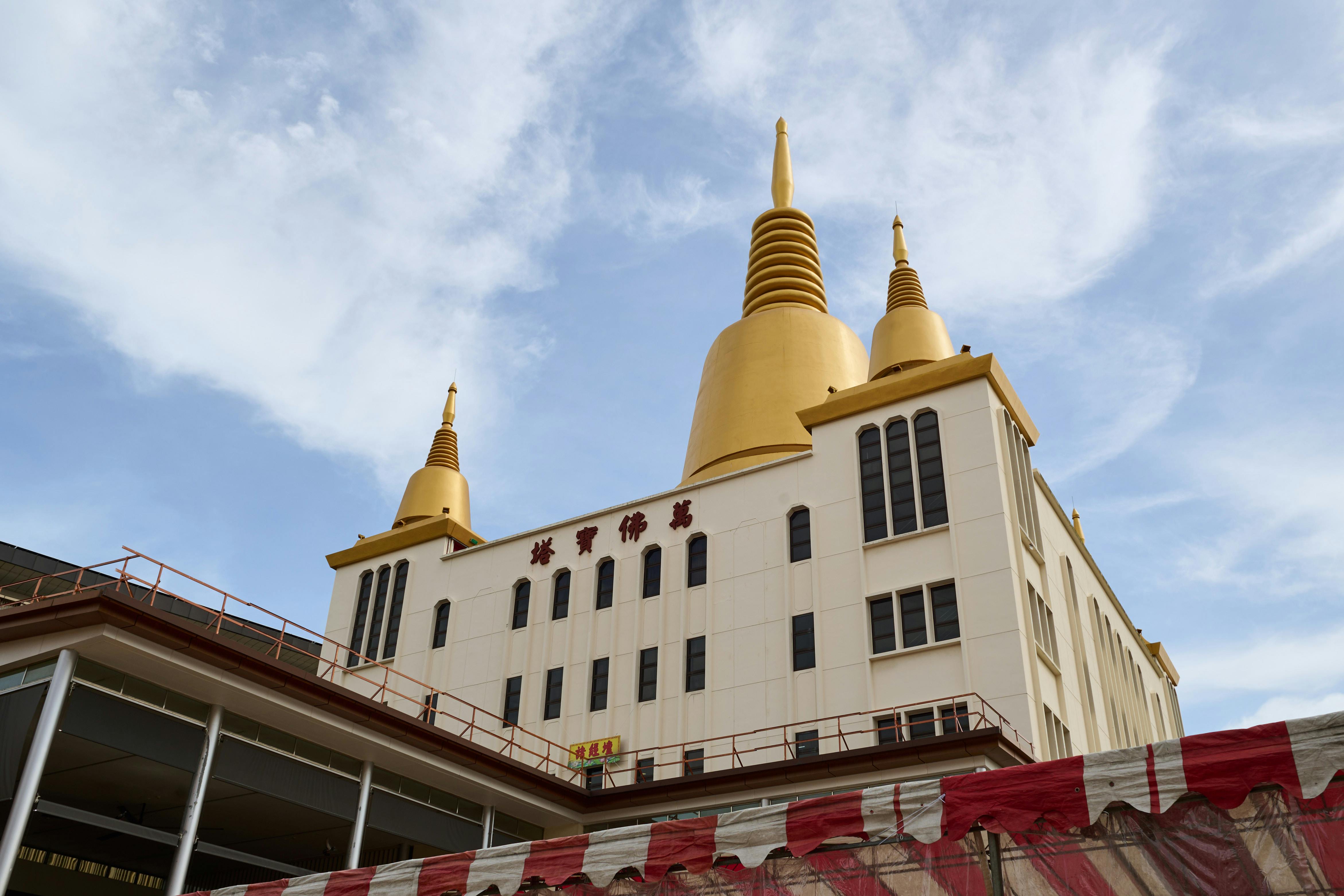 Stunning view of a temple with golden spires under a blue sky, showcasing its architectural beauty.