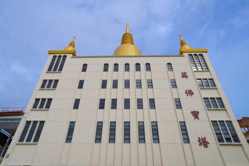 Free A building with golden spires and Asian architectural elements under a clear blue sky. Stock Photo