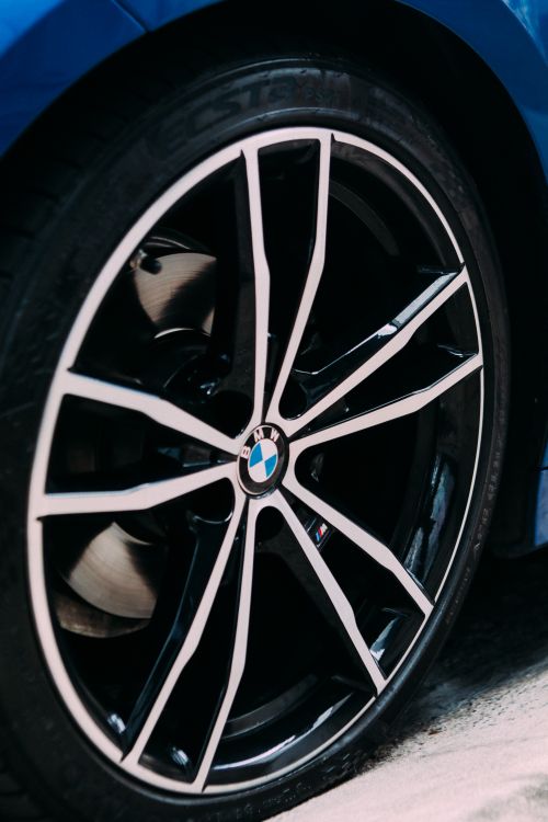 Free Close-up image of a luxury car wheel with sleek rim design, showcasing elegance and performance. Stock Photo