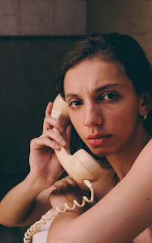 A woman using a vintage telephone, conveying a thoughtful and nostalgic vibe.