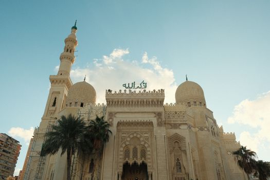Stunning view of a mosque with intricate architecture against a bright blue sky.