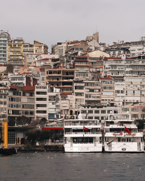 Free View of crowded buildings and ferries along Istanbul's Bosphorus shoreline, a bustling scene Stock Photo