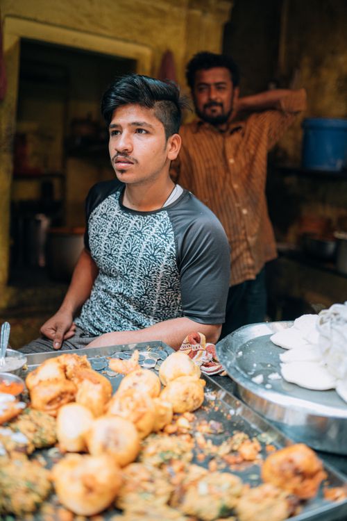 Free Local street food vendor selling snacks in Varanasi, India, showcasing Indian cuisine. Stock Photo