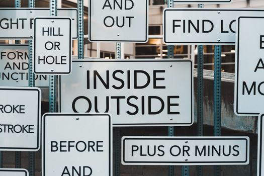 A creative display of street signs in Salt Lake City, showcasing contrasting messages and typography.