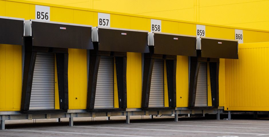 Industrial loading bay doors on a factory wall — the external perimeter zone where toxic rodent bait is permitted