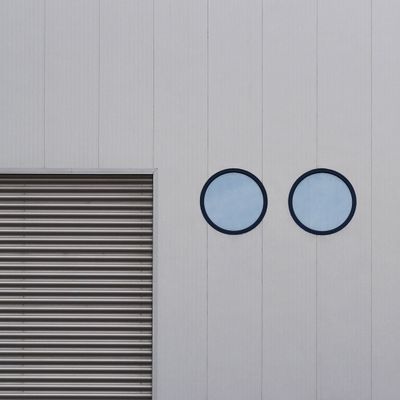 Abstract minimalist facade with circular windows — photo by Simeon Galabov on Pexels