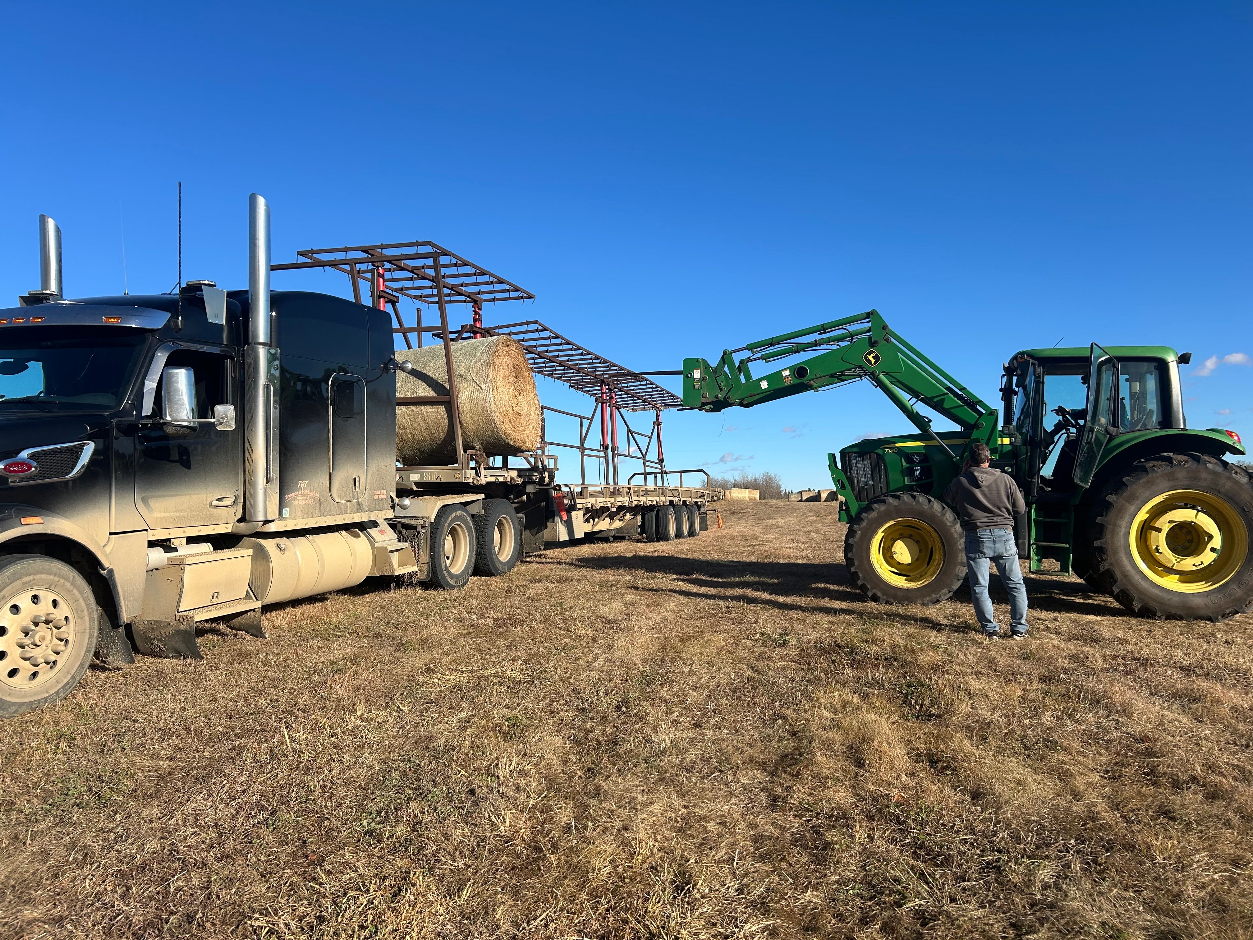 Tractor Loading Hay Bales onto Truck in Field · Free Stock Photo
