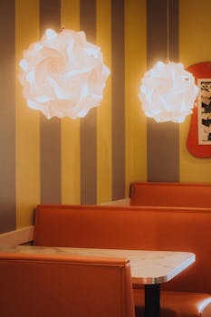 Cozy retro diner interior featuring warm ambient lighting and orange booths.
