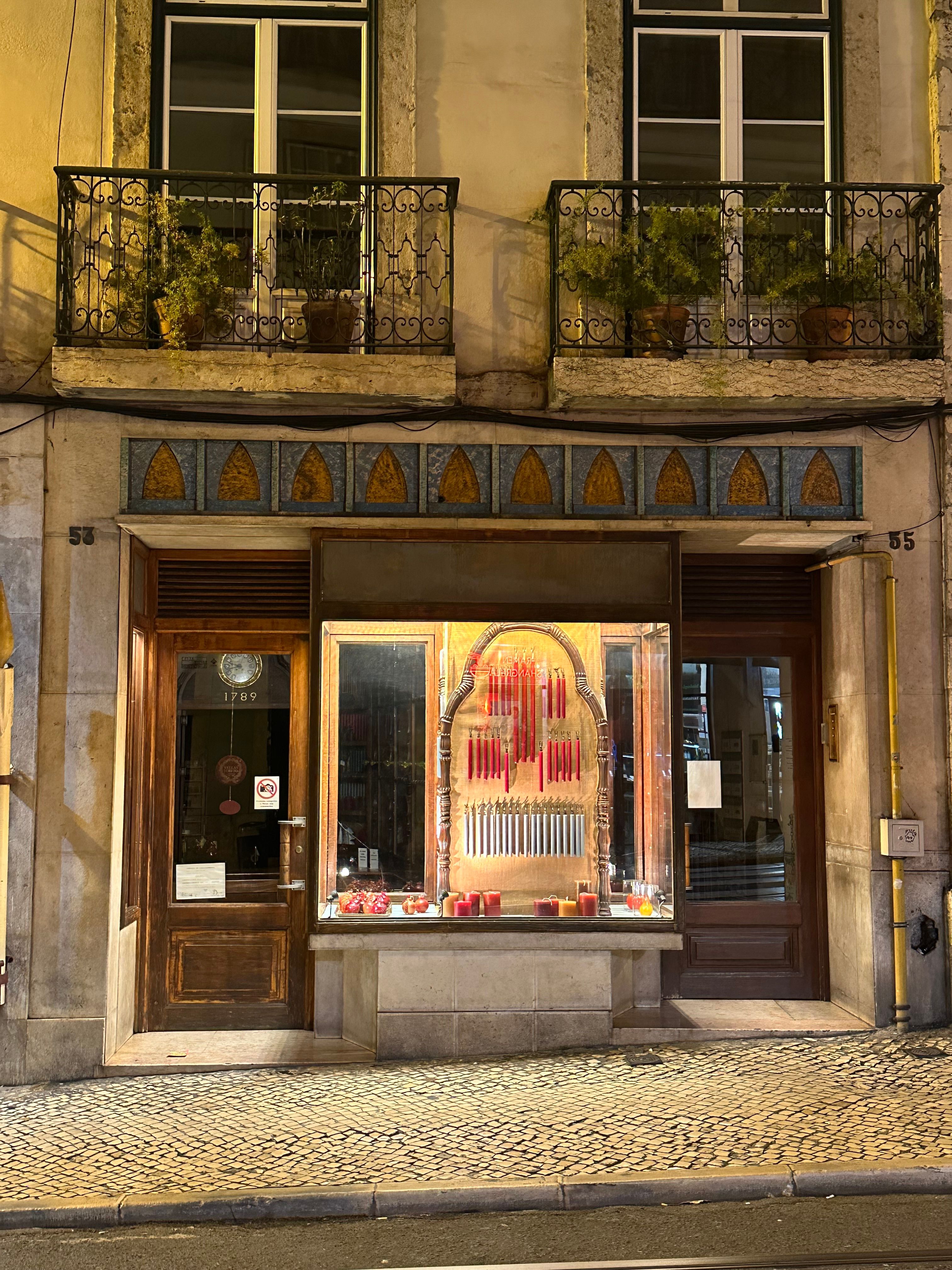 Charming candle shop in Lisbon's historic district, featuring a warm nighttime glow.