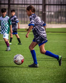 Young players engaged in a dynamic soccer match on a sunny day, showcasing youthful energy and teamwork.