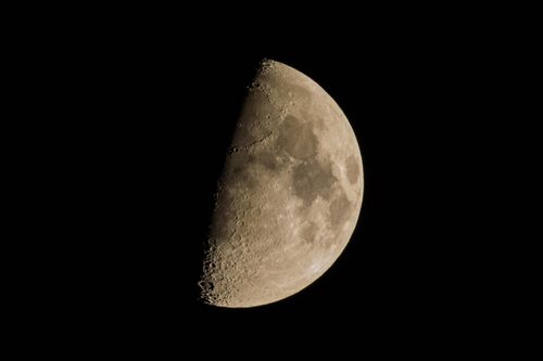 Free Captivating image of the first quarter moon showcasing its craters in clear detail against a dark night sky. Stock Photo