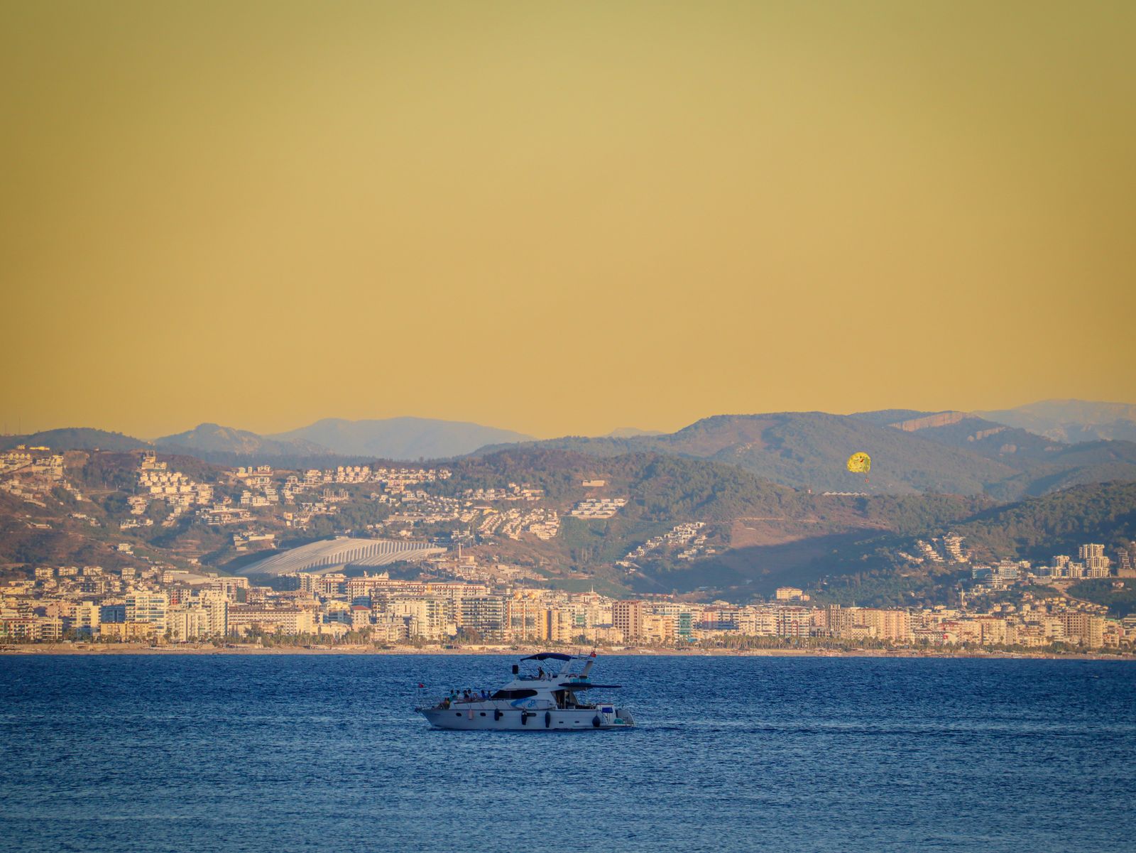 A yacht on San Diego Bay at sunset with the city skyline in the background