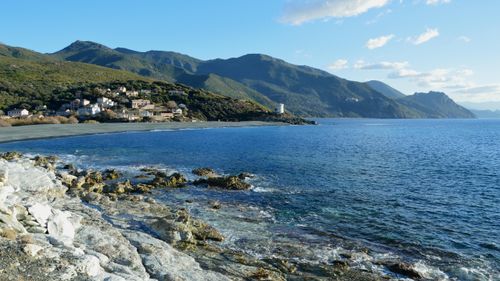 Free Beautiful coastal landscape of Ogliastro, Corse, France with rocky shore and distant hills. Stock Photo