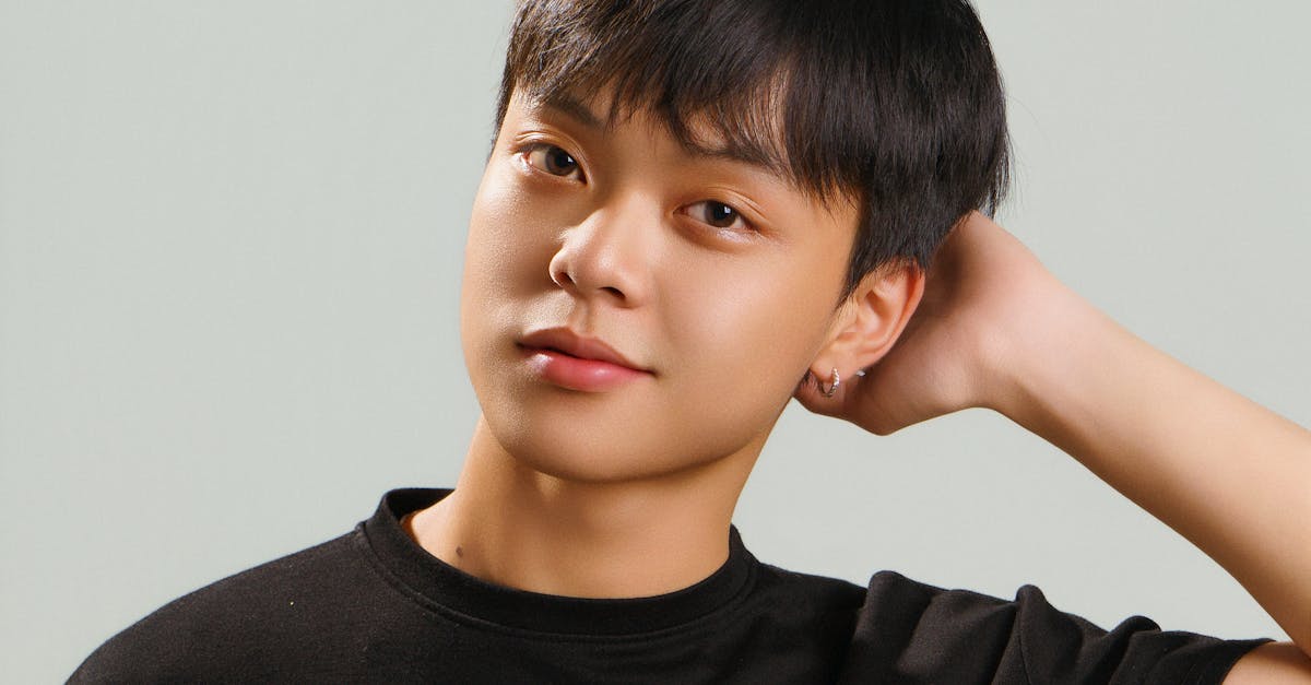 Studio portrait of a young Asian male model in a black t-shirt with a casual pose.