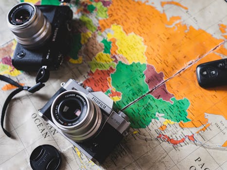 两台老式相机被放置在充满活力的世界地图上，以展示旅行主题