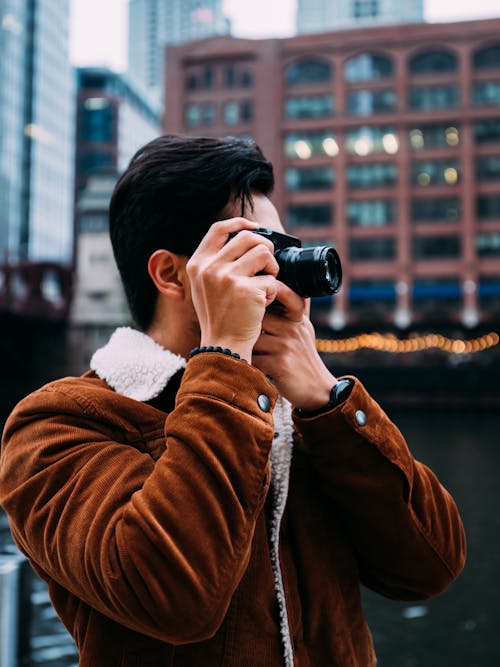 Hombre De Chaqueta Marrón Con Cámara Dslr Negra