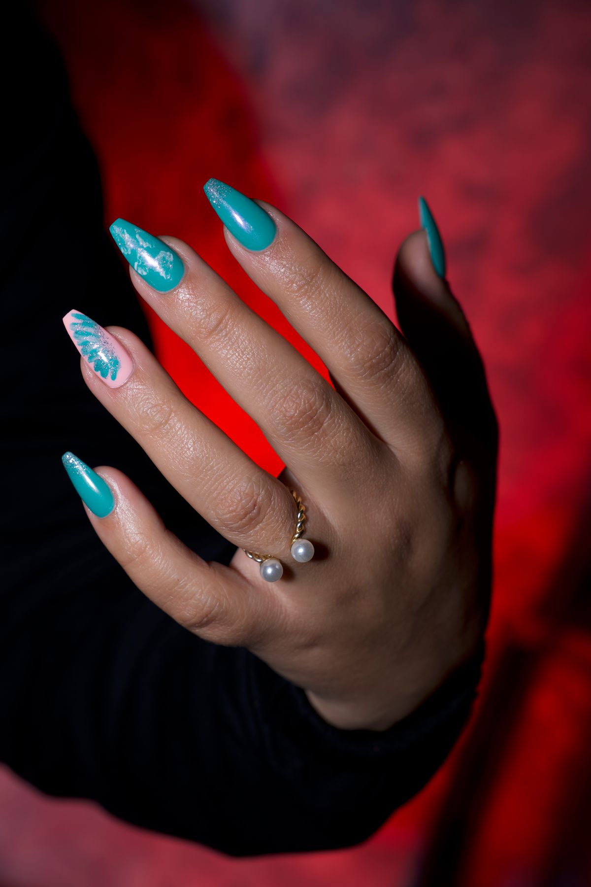 Elegant hand with turquoise gel nails and a ring