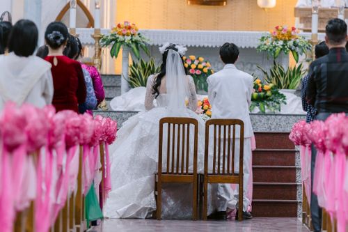 Free Bride and groom at a beautiful church wedding ceremony with floral decorations. Stock Photo