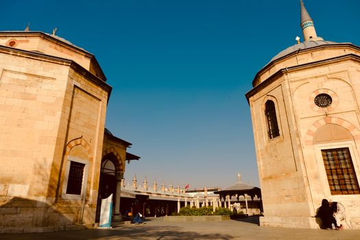 A tranquil courtyard of a historic mosque in the Middle East under a clear blue sky.