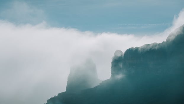 Misty clouds envelop sandstone peaks in Monument Valley, Arizona.