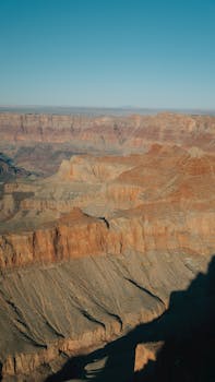 Breathtaking view of the Grand Canyon's red rock formations under a clear blue sky in Arizona.