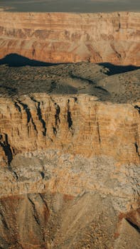 A stunning aerial view of the Grand Canyon's rocky formations under a clear sky in Arizona.
