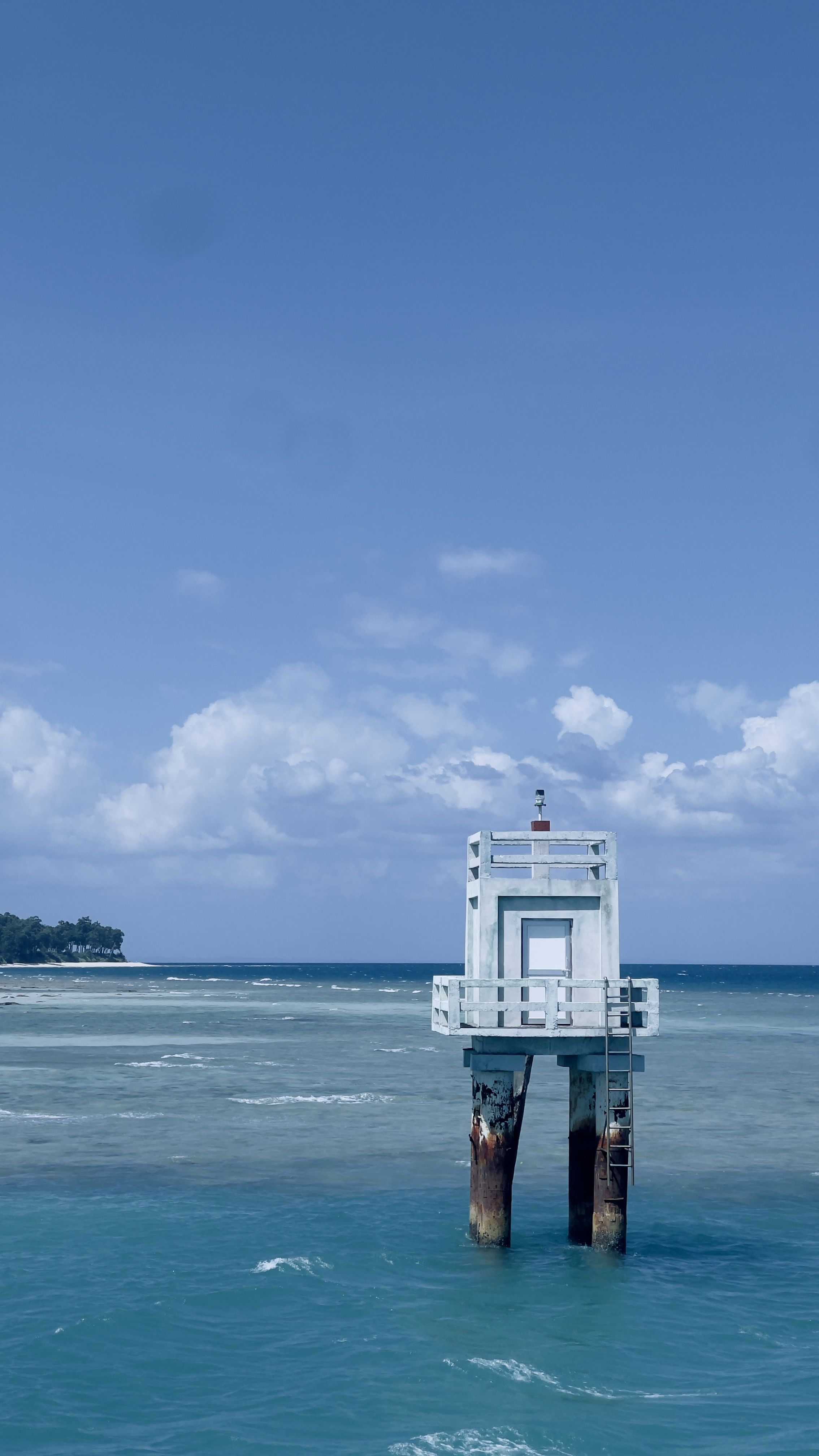 Isolated Weathered Lighthouse in Tranquil Blue Sea