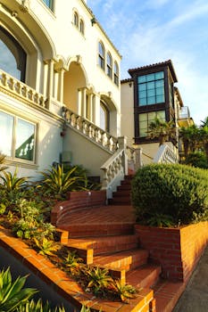 Elegant Mediterranean-style house with lush greenery and terracotta steps.