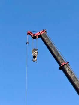A towering construction crane against a vibrant blue sky, showcasing industrial progress.