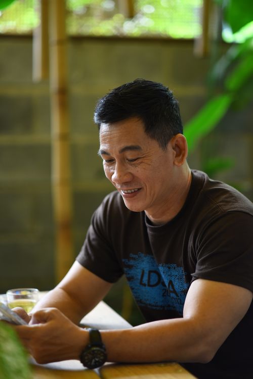 Free Casual portrait of an asian man enjoying leisure time with his smartphone at a cafe. Stock Photo