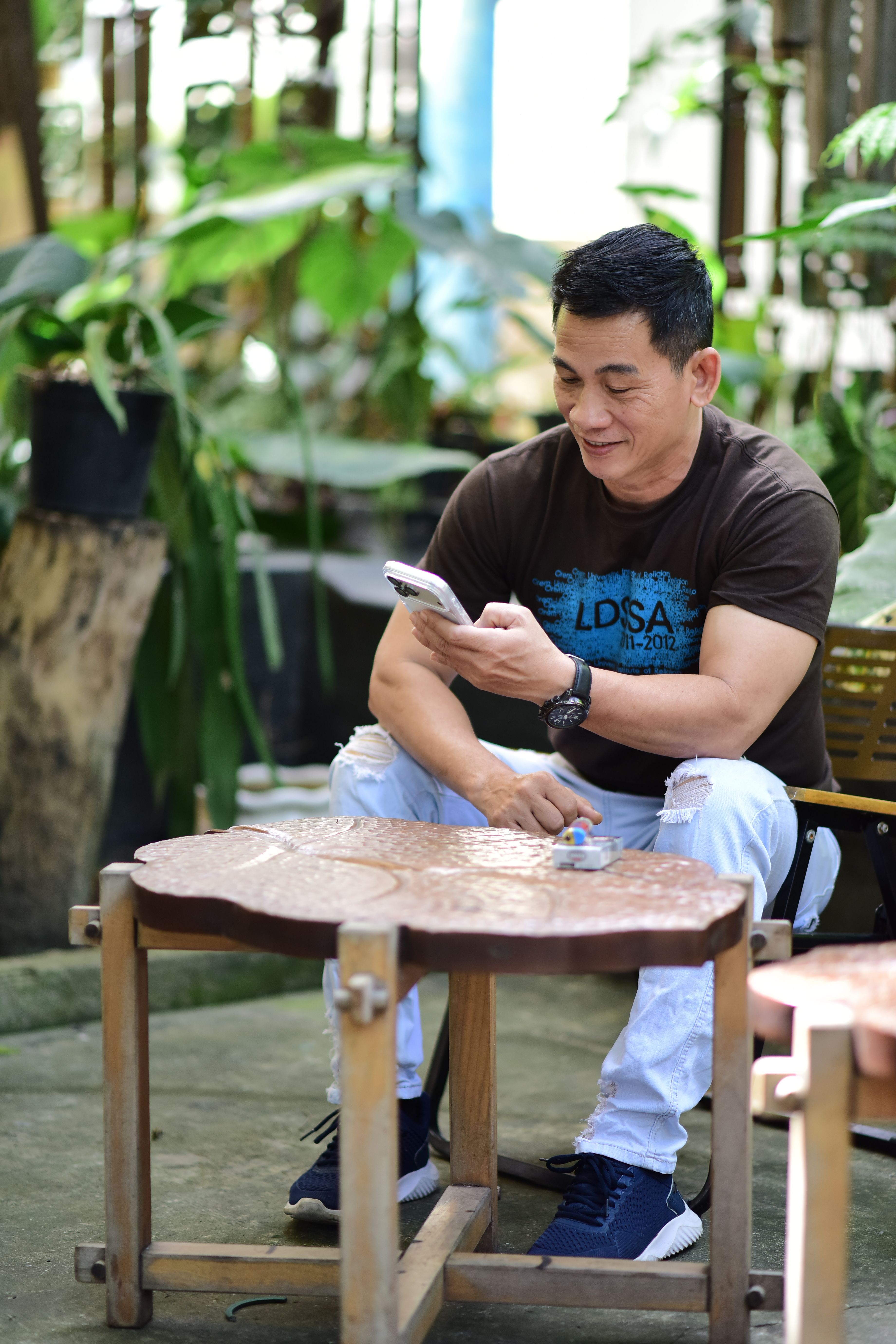 Man enjoying a sunny day outdoors while using his smartphone.