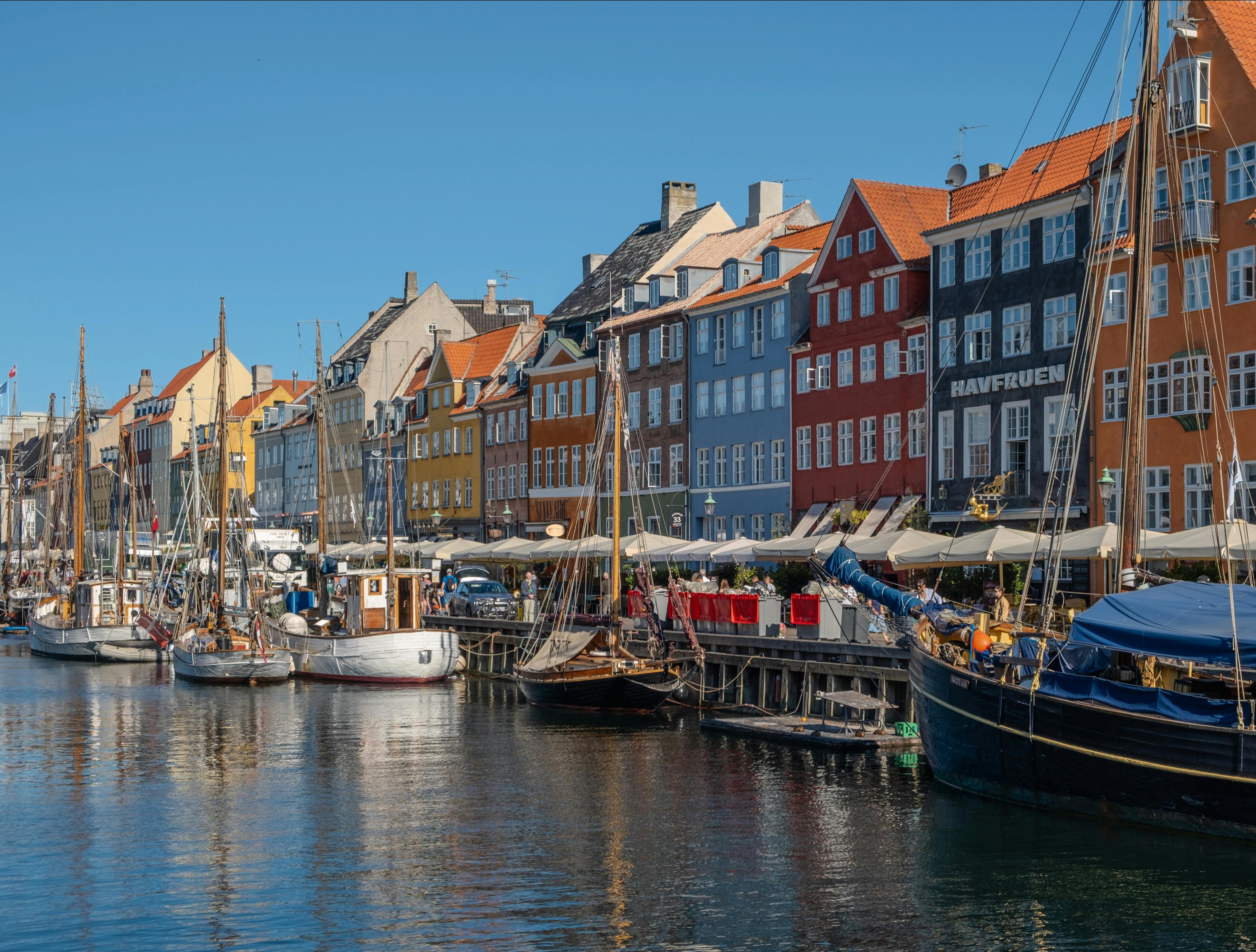 Scenic view of anchored boats and vibrant buildings at Nyhavn in Copenhagen, Denmark.