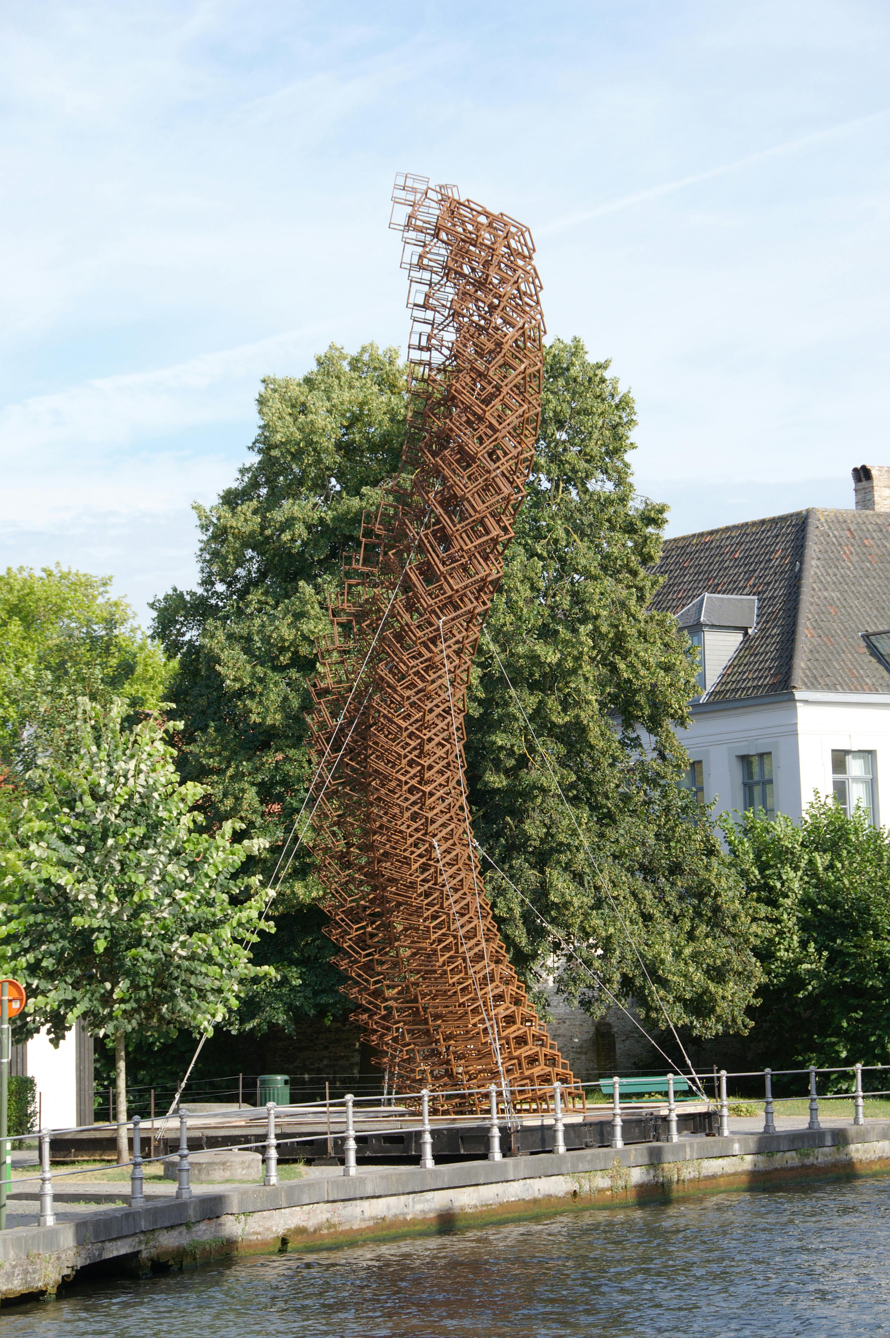 Artistic metal sculpture by Bruges canal, a stunning city landmark.