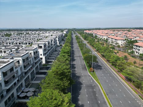 Aerial shot of a modern housing estate in Dong Nai, Vietnam, showcasing luxury homes and a wide road.