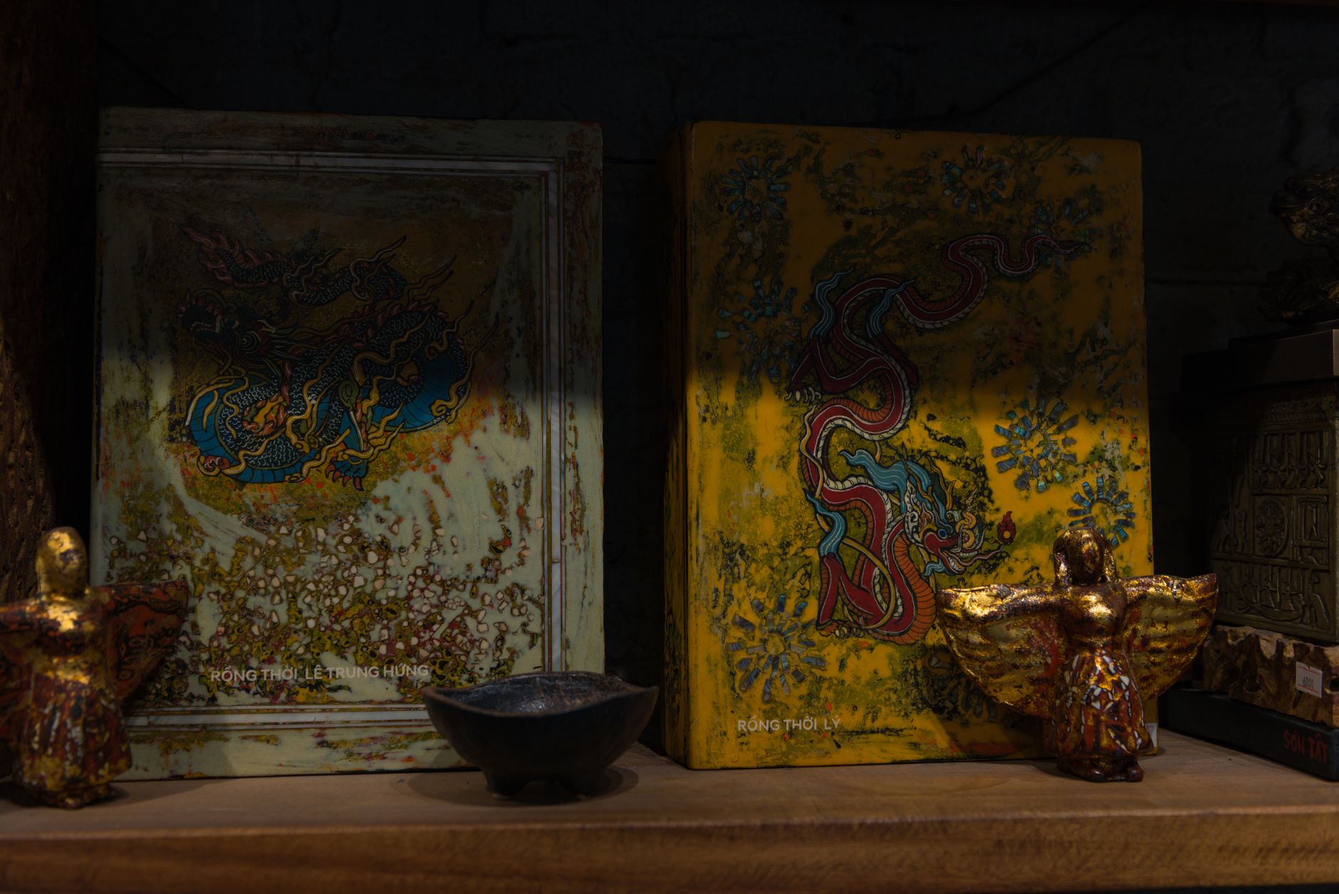 Two intricate Vietnamese art pieces with dragon motifs displayed in a Hanoi shop.
