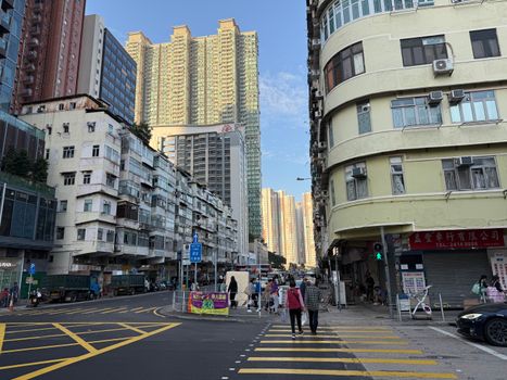Vibrant street view of urban life in Kowloon, Hong Kong with towering buildings and pedestrians.