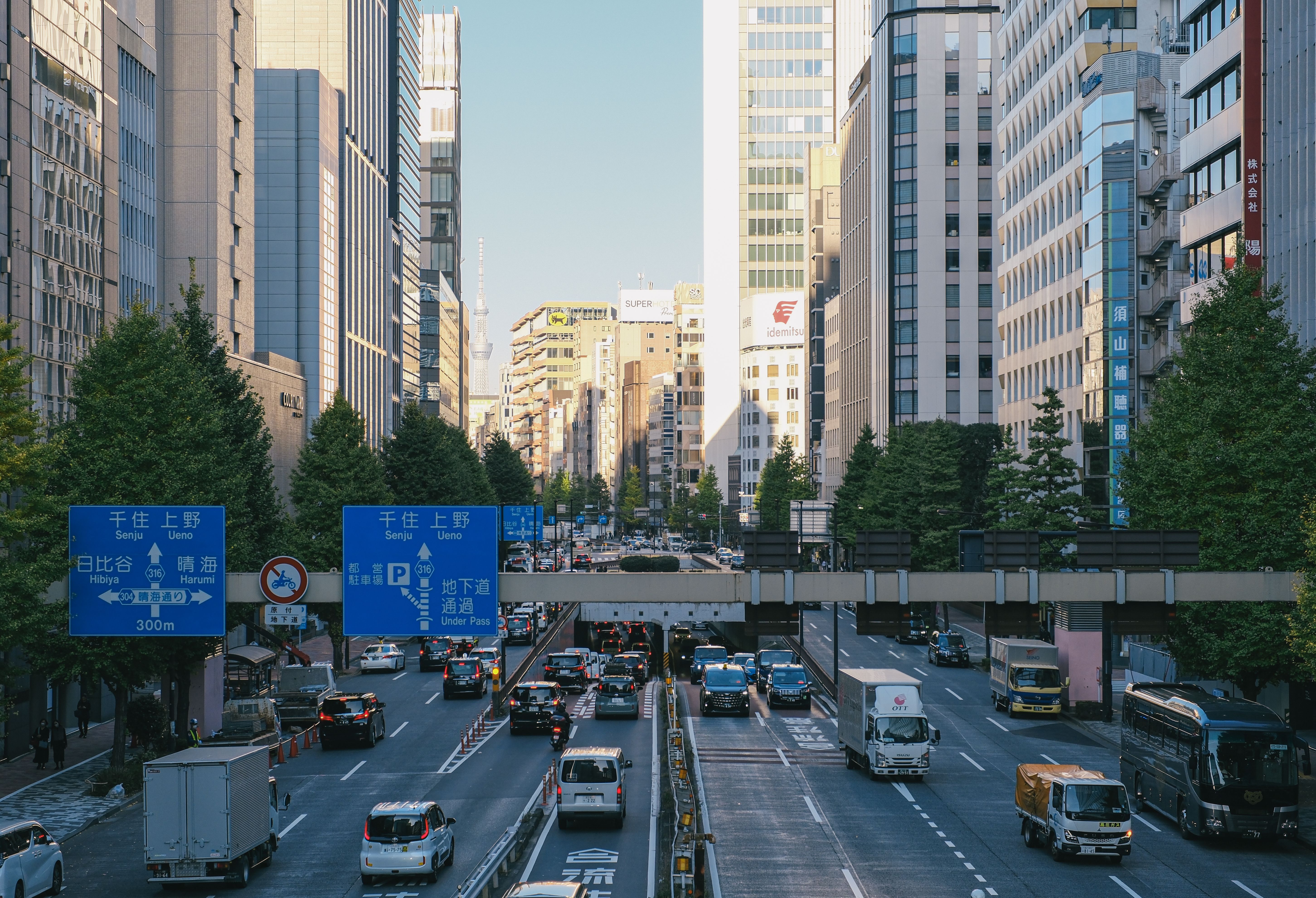 Bustling city street view in Tokyo with traffic and skyscrapers under daylight.