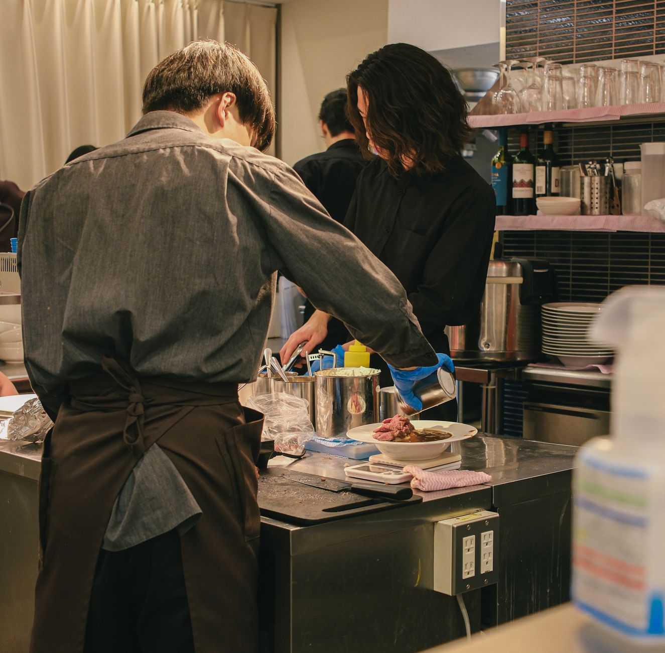 飲食店の店先で悩むオーナーの写真、またはチラシを配る様子