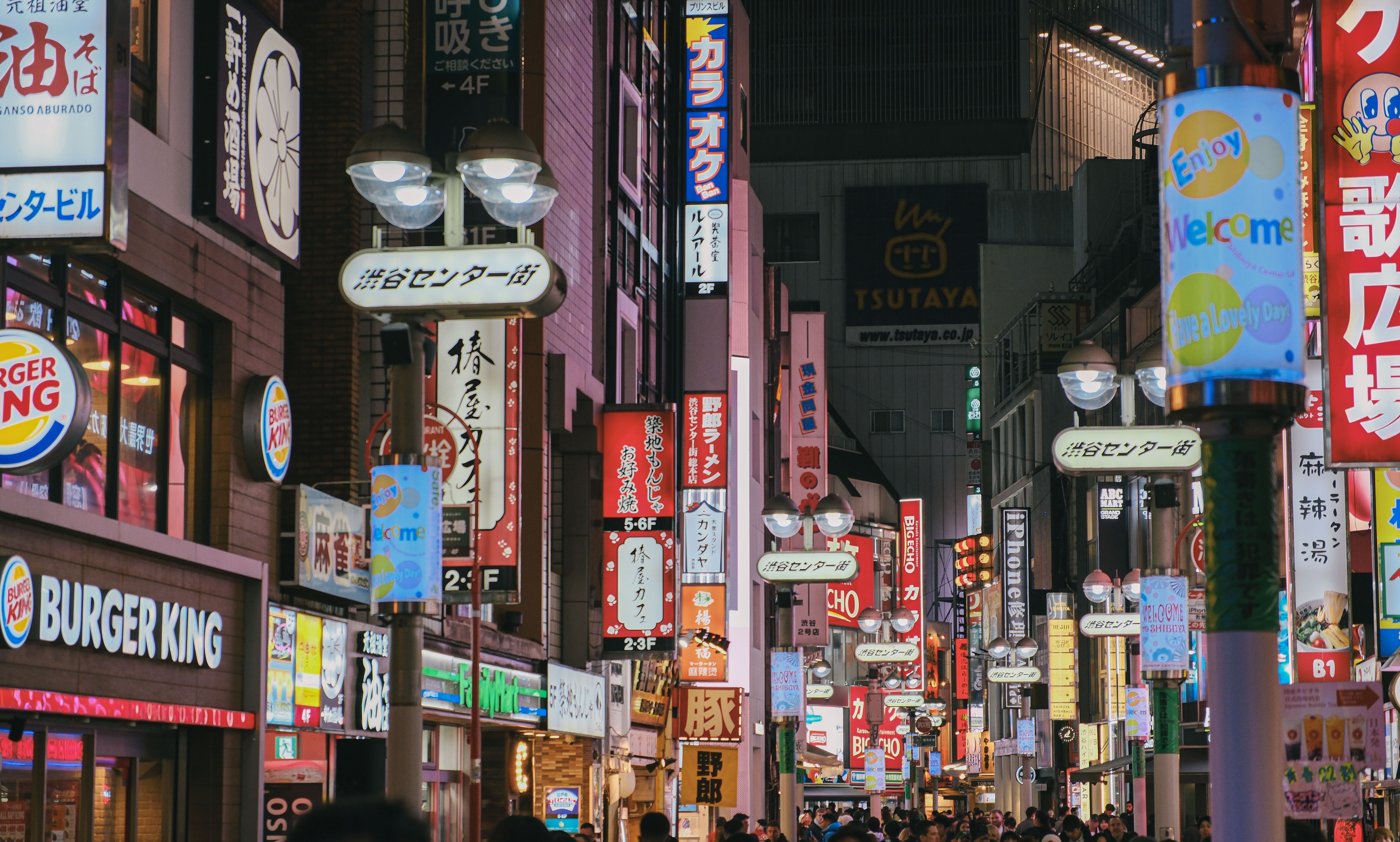 Gratuit Rue illuminée de néons colorés dans le quartier animé de Shibuya à Tokyo, grouillante de monde et de boutiques. Photos