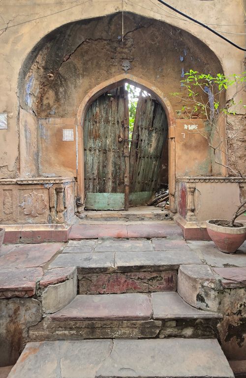 Free Old stone archway with rustic wooden door, reflecting historical architecture. Stock Photo