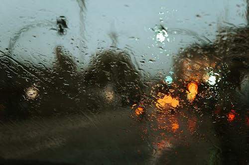 Free Road in modern city street with lights through car window in rainy weather Stock Photo