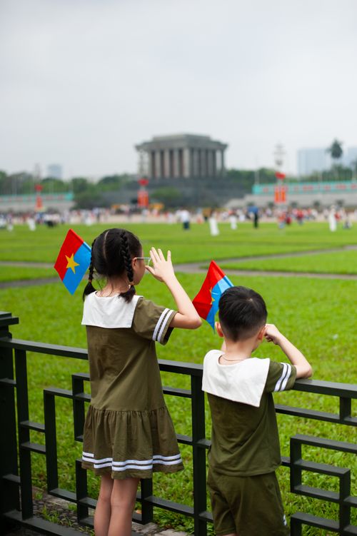 Free Children with flags at Ho Chi Minh Mausoleum, Hanoi, Vietnam, vibrant atmosphere. Stock Photo