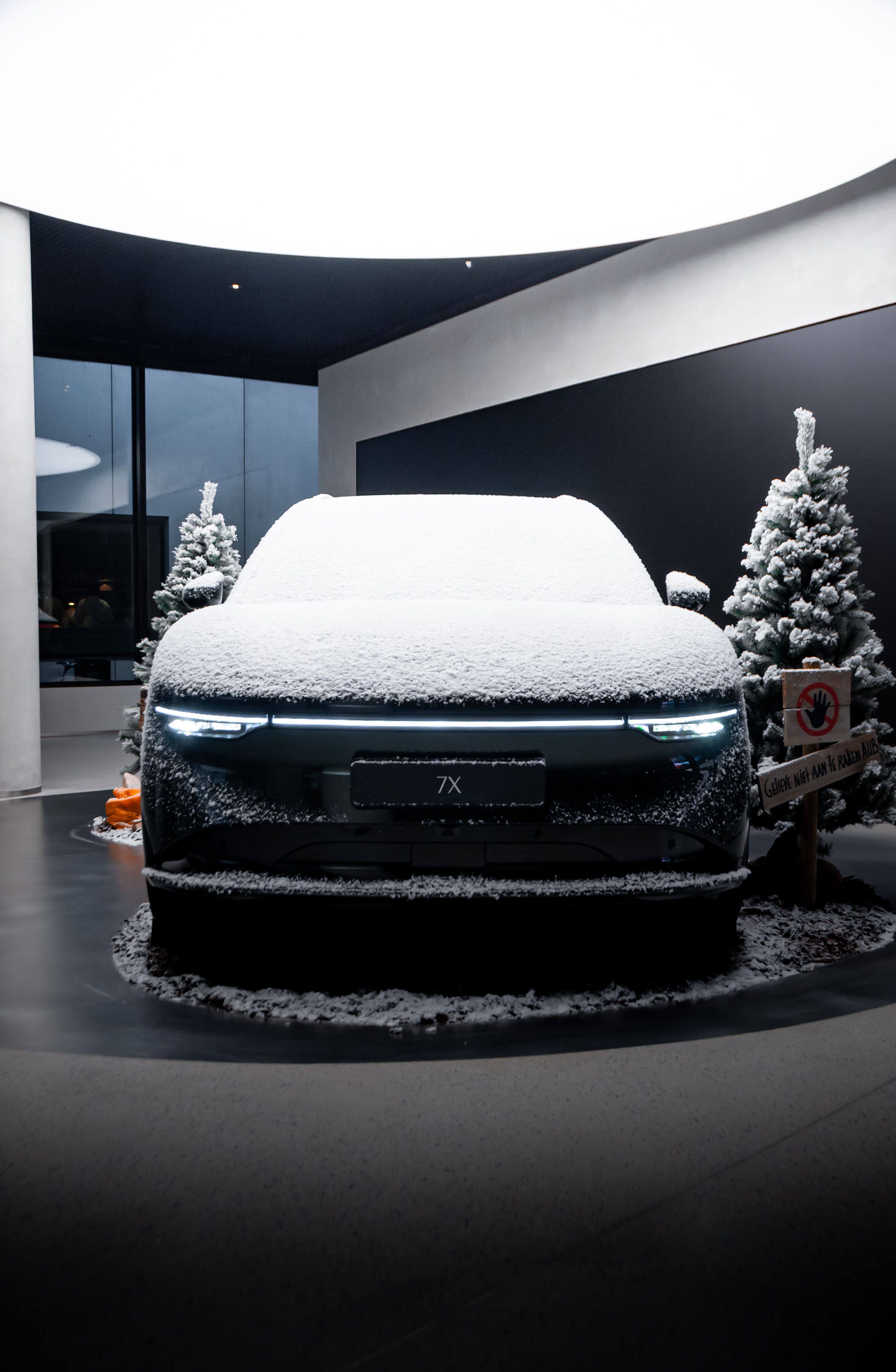 Snow-covered Zeekr electric car displayed indoors with fir trees — Chinese EV European winter market expansion