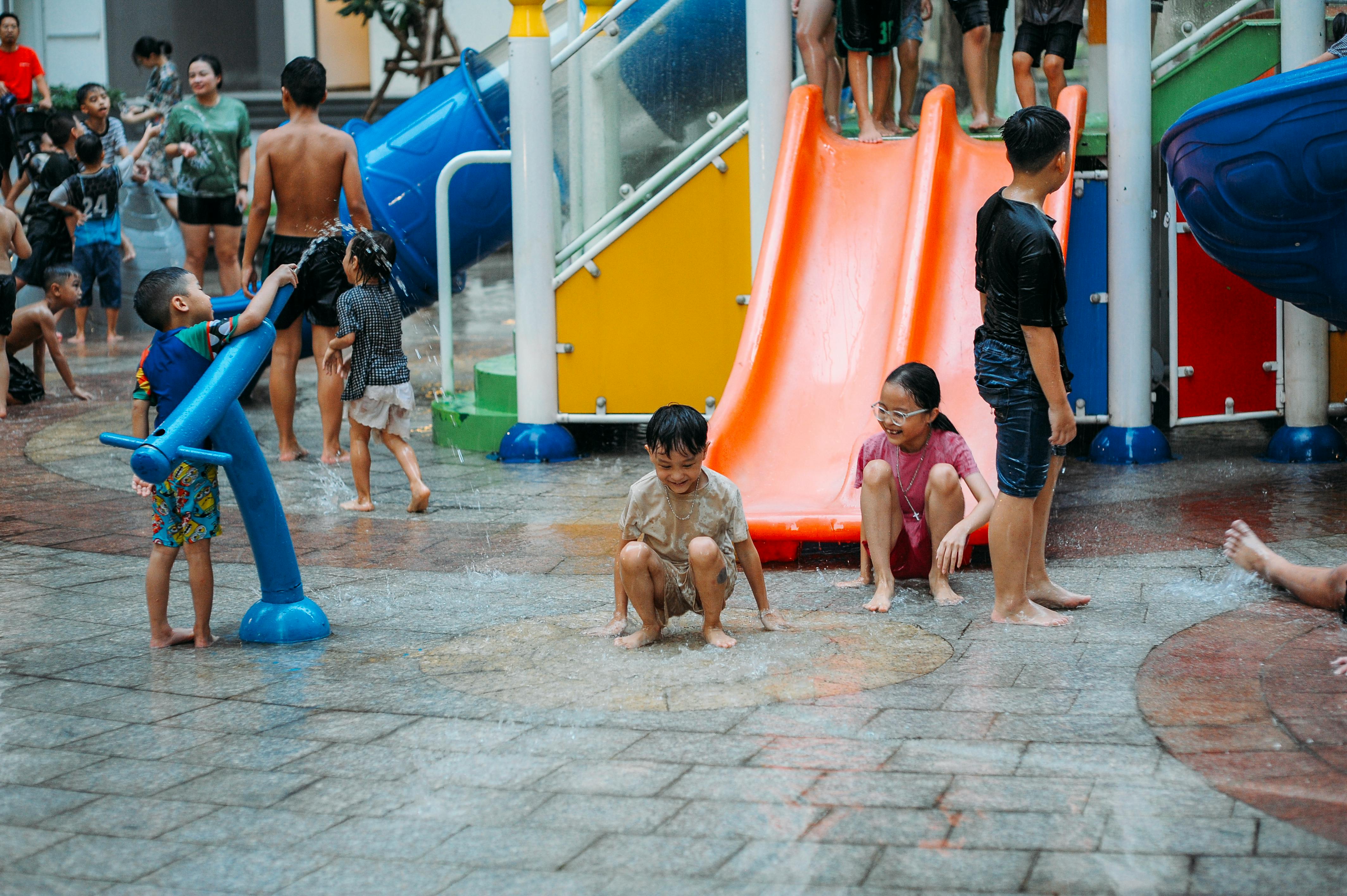 Children playing at the water playground at Gardens by the Bay Singapore, with Supertrees visible in the background