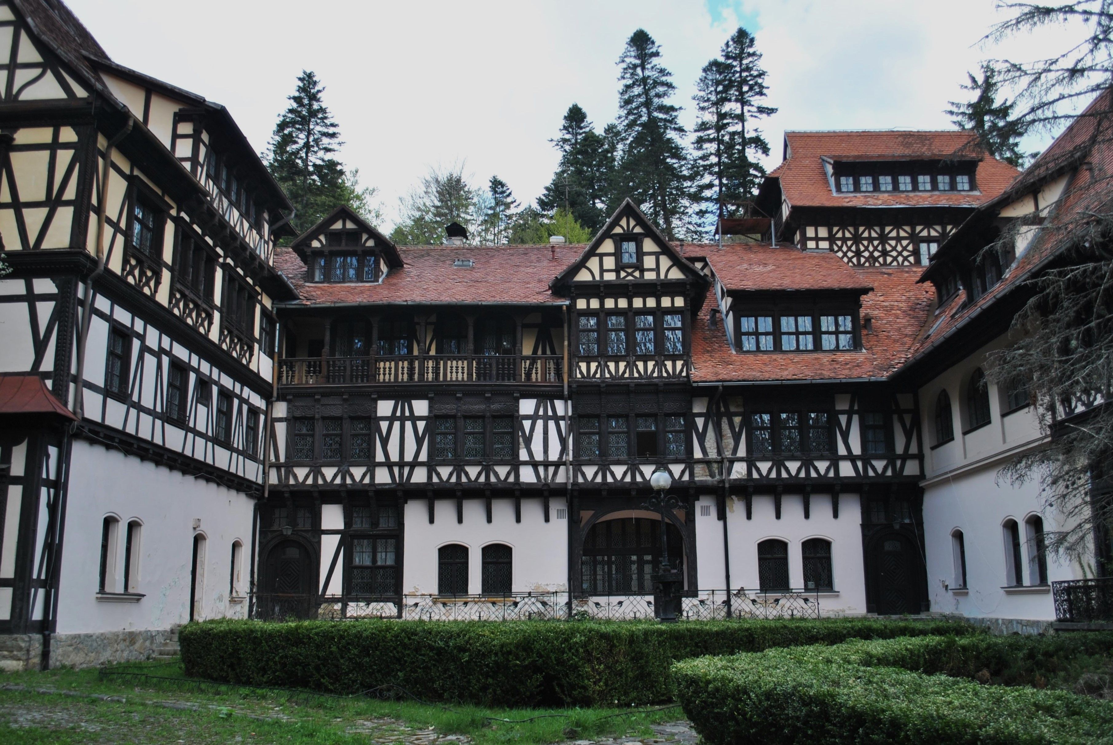 Charming Tudor architectural building surrounded by lush forest, showcasing classic design and serenity.