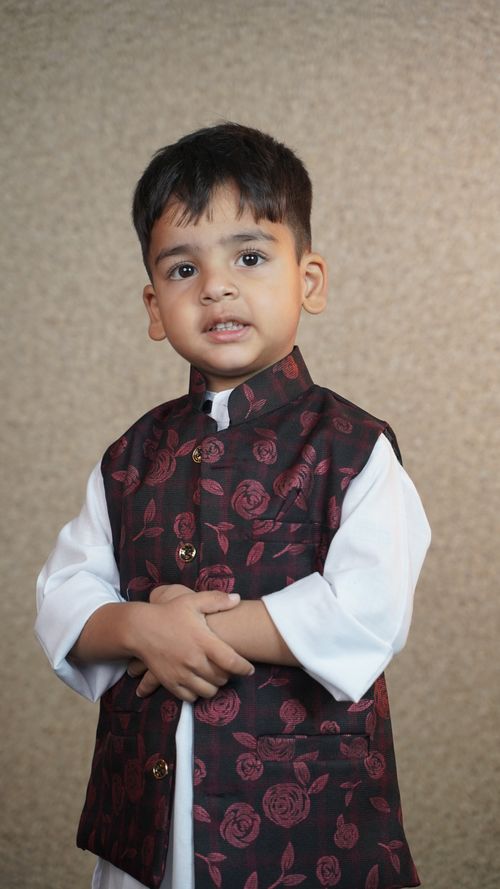 Free Cute young child dressed in traditional attire posing against a neutral background. Stock Photo
