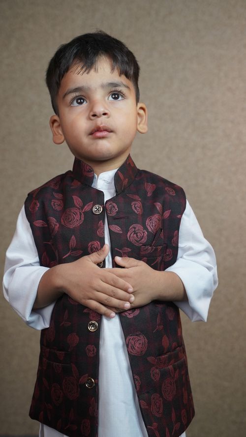 Free A young child in a traditional Kashmiri outfit poses indoors with a thoughtful expression. Stock Photo