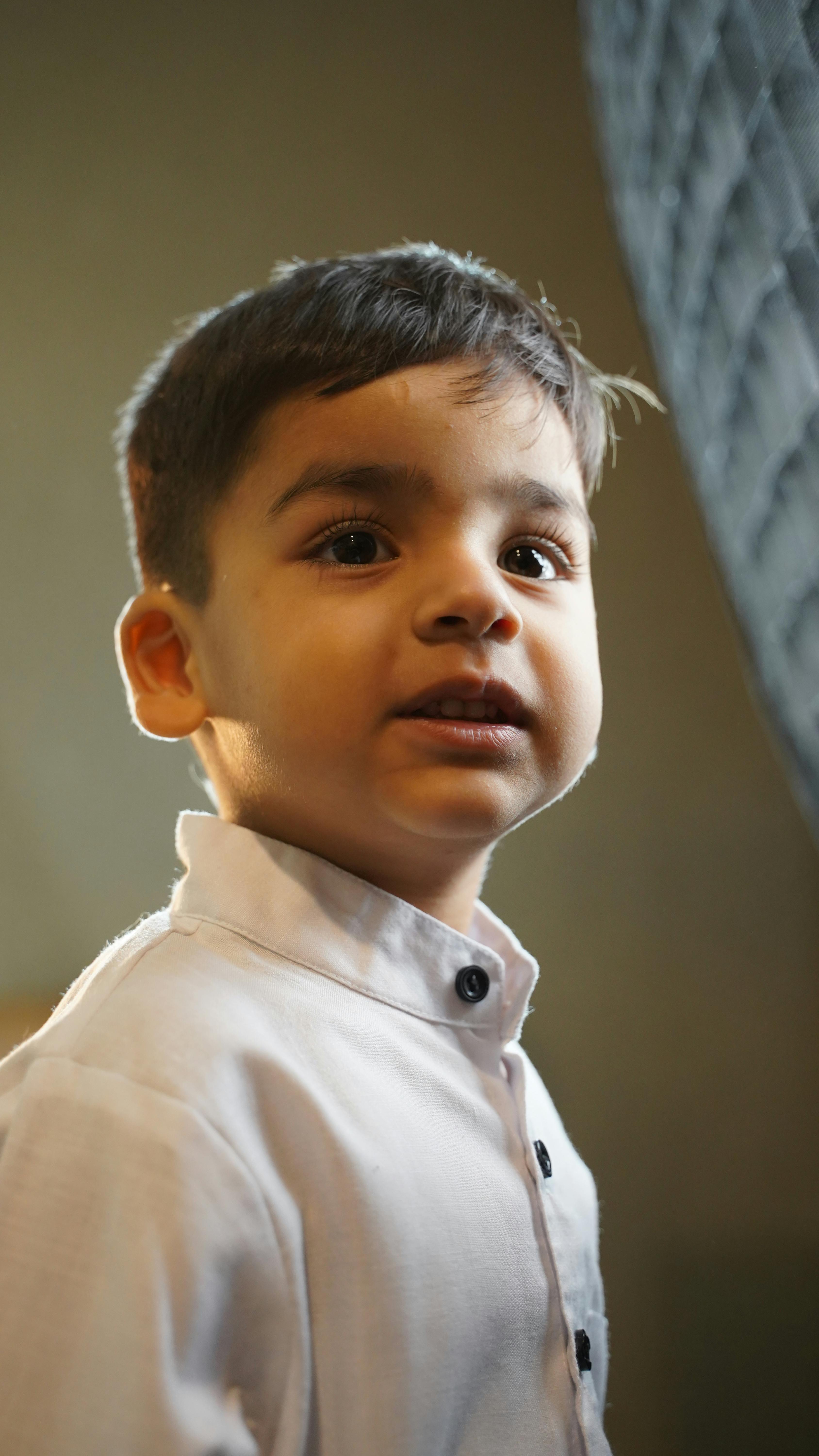 Gratis Encantador retrato de un niño pequeño en un interior, capturado con una iluminación suave y una atmósfera cálida. Foto de stock